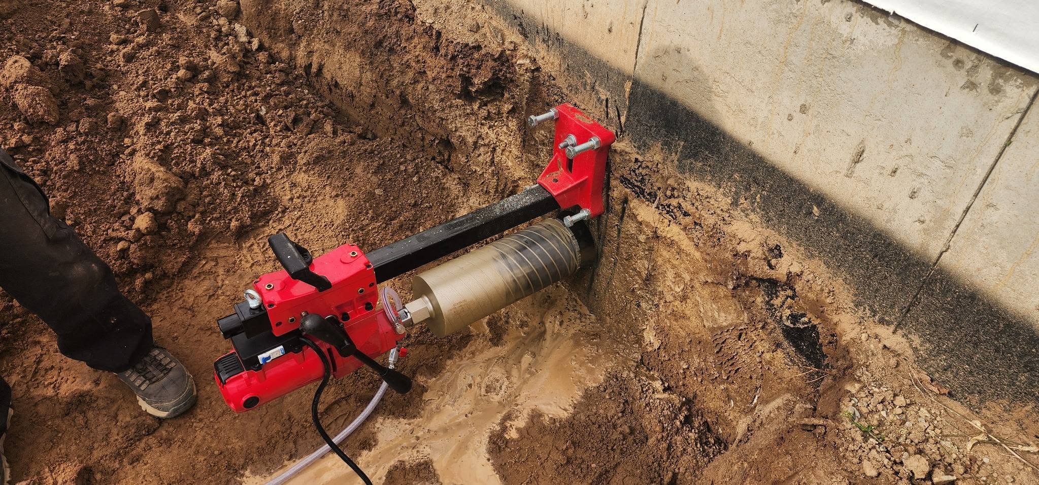 Core drilling a concrete foundation wall for a septic line penetration
